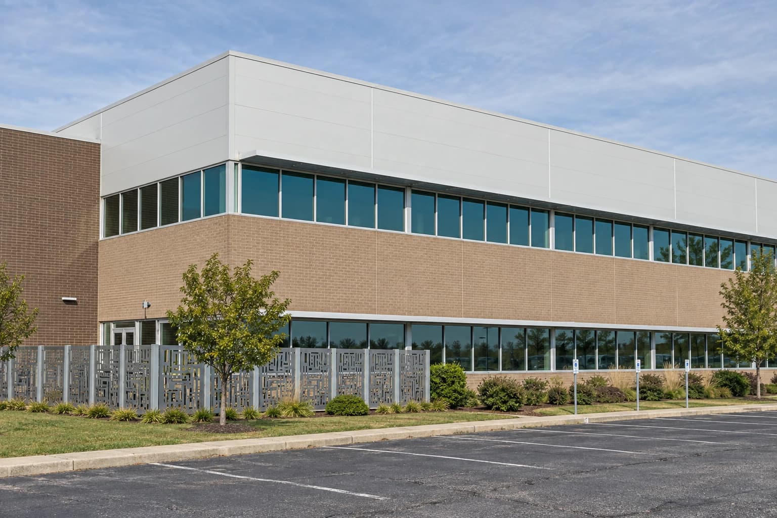 Concept view of a two-story call-center building with tan brick walls, plain white panels and teal windows beside an ordinary parking lot