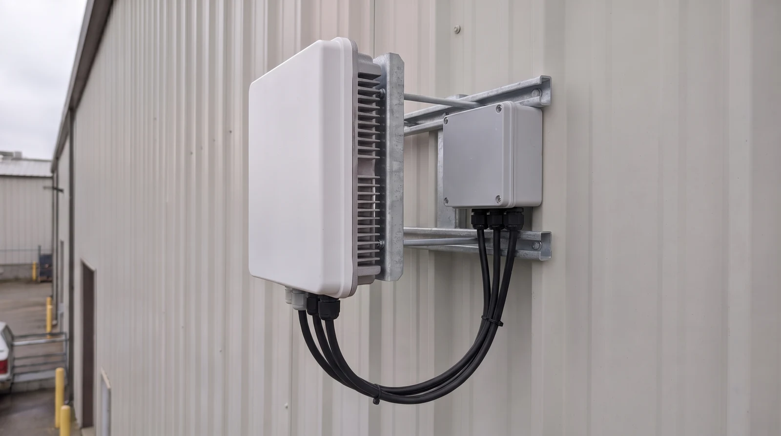 An outdoor cellular radio and closed connection box mounted on a warehouse exterior