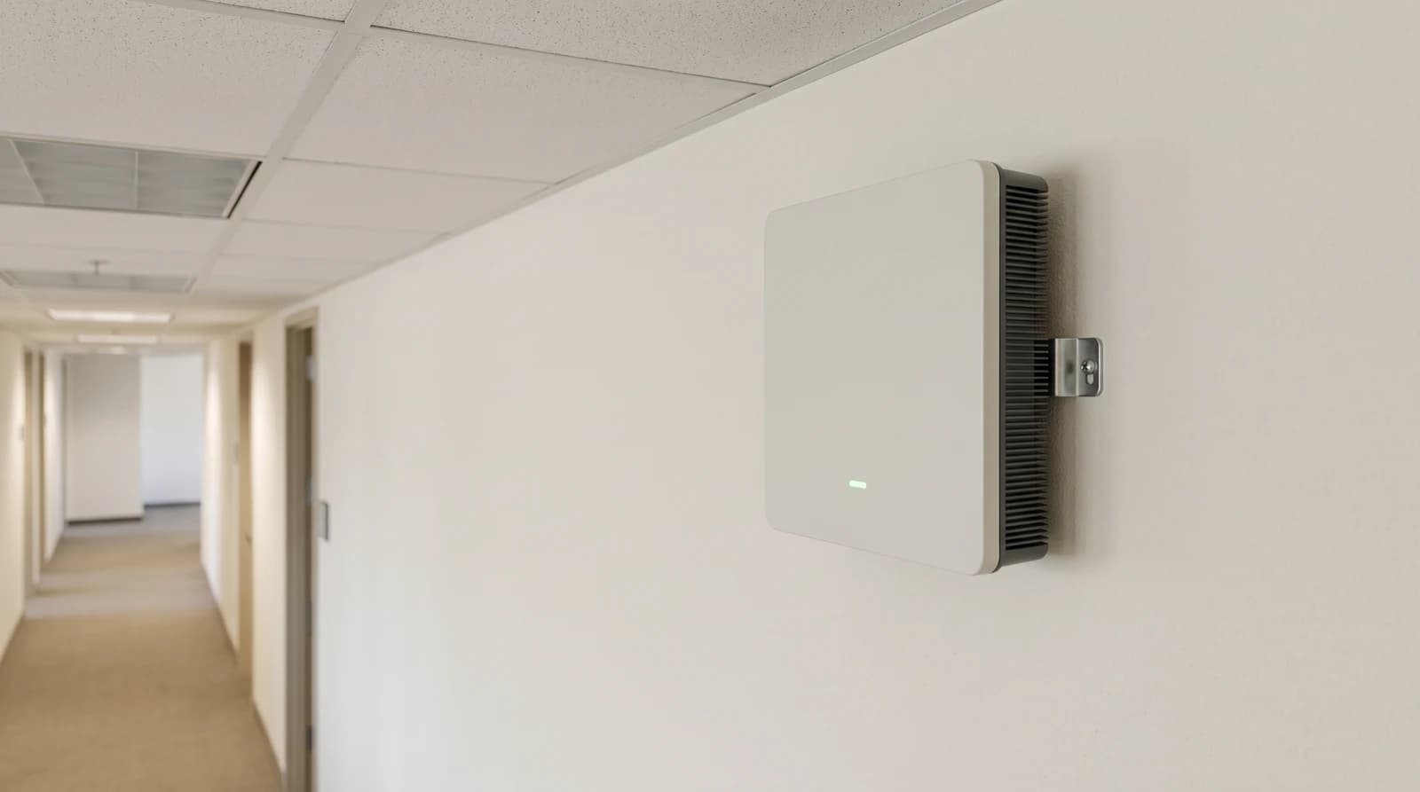 A compact rectangular indoor cellular radio mounted high on a commercial office wall