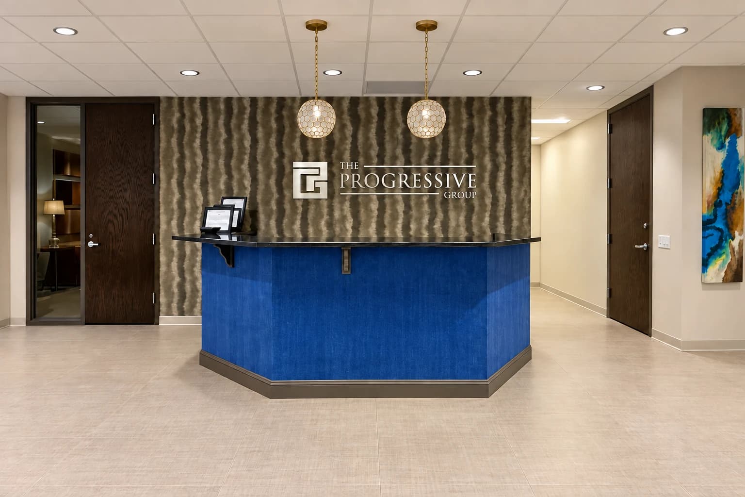 A blue reception desk beneath the Progressive Group wall sign at the Macon headquarters