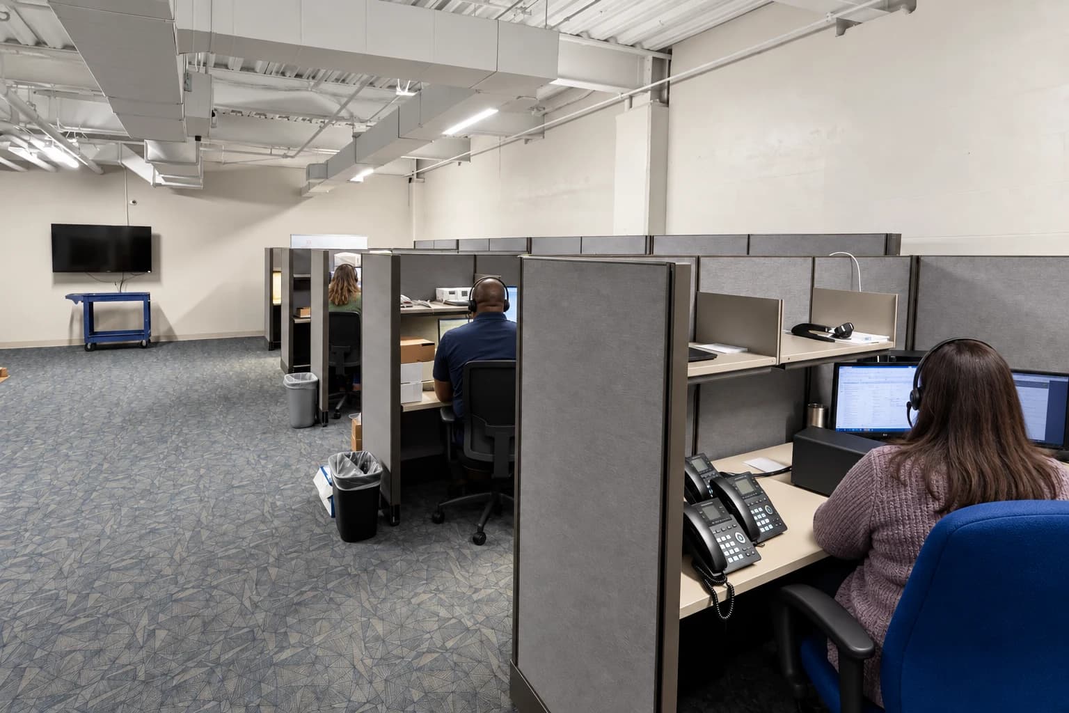Macon customer support workspace with staff seated at their workstations, viewed from behind
